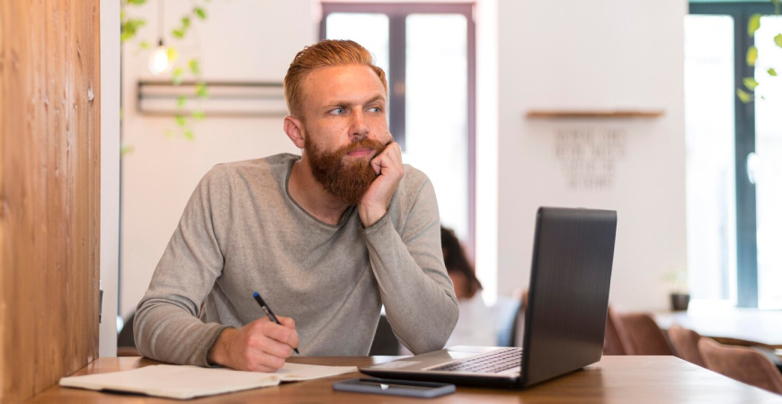 Empresário pensativo diante do notebook analisando os desafios da reforma tributária para pequenas empresas